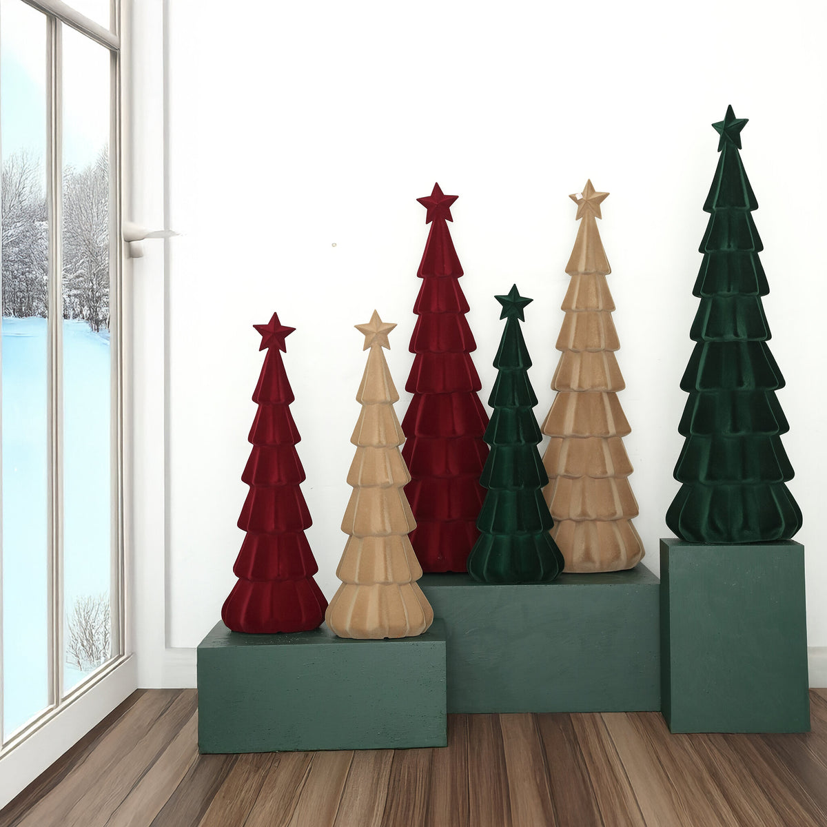 Yule Kerstboom Gelaagd Beige Large van PTMD, gelaagde kerstbomen in drie kleuren op een groen podium bij het raam