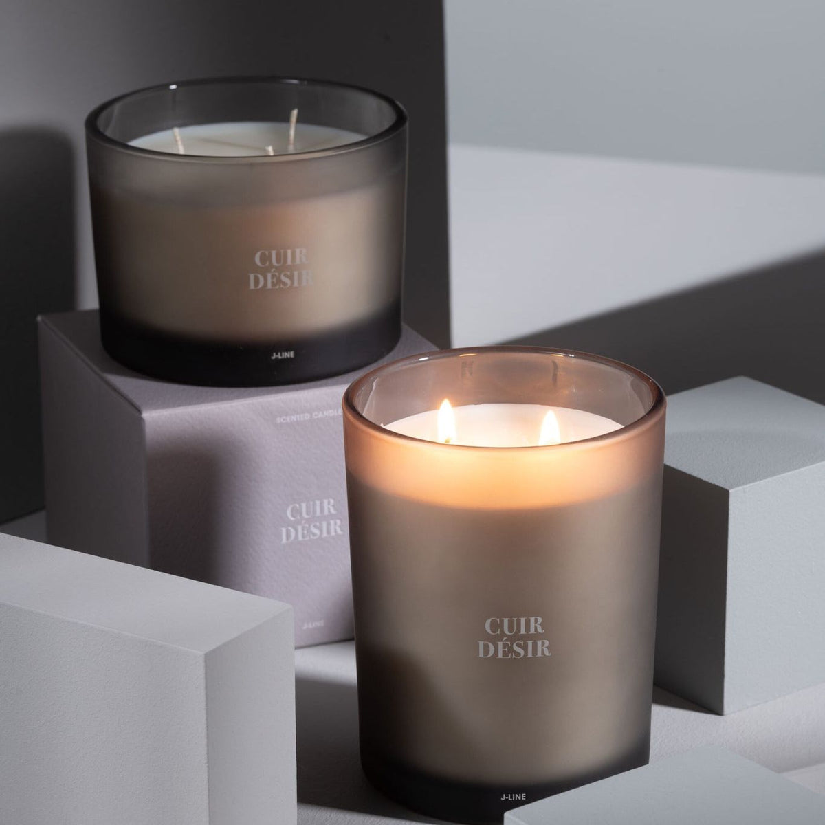 Geurkaars Accords Essentiels Cuir Désir 28 Uur van J-Line op decoratieve blokken in een warme sfeerfoto