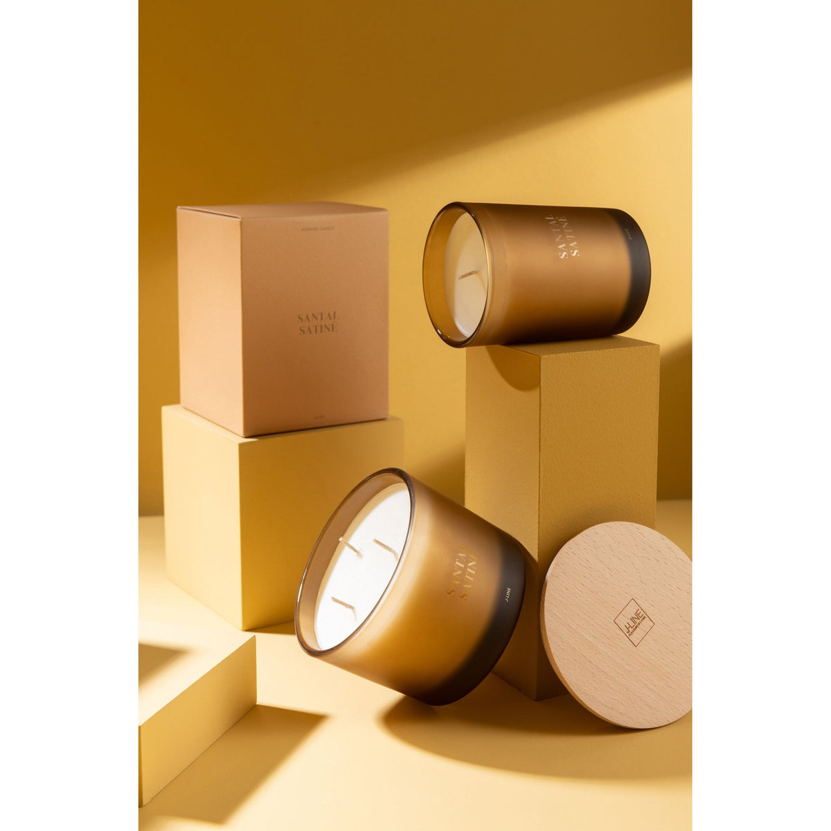 Geurkaars Accords Essentiels Santal Satiné 28 Uur van J-Line op decoratieve blokken in een warme sfeerfoto