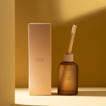 Geurstokjes Accords Essentiels Santal Satiné 250ml van J-Line met bijpassende doos in een sfeervolle gele setting