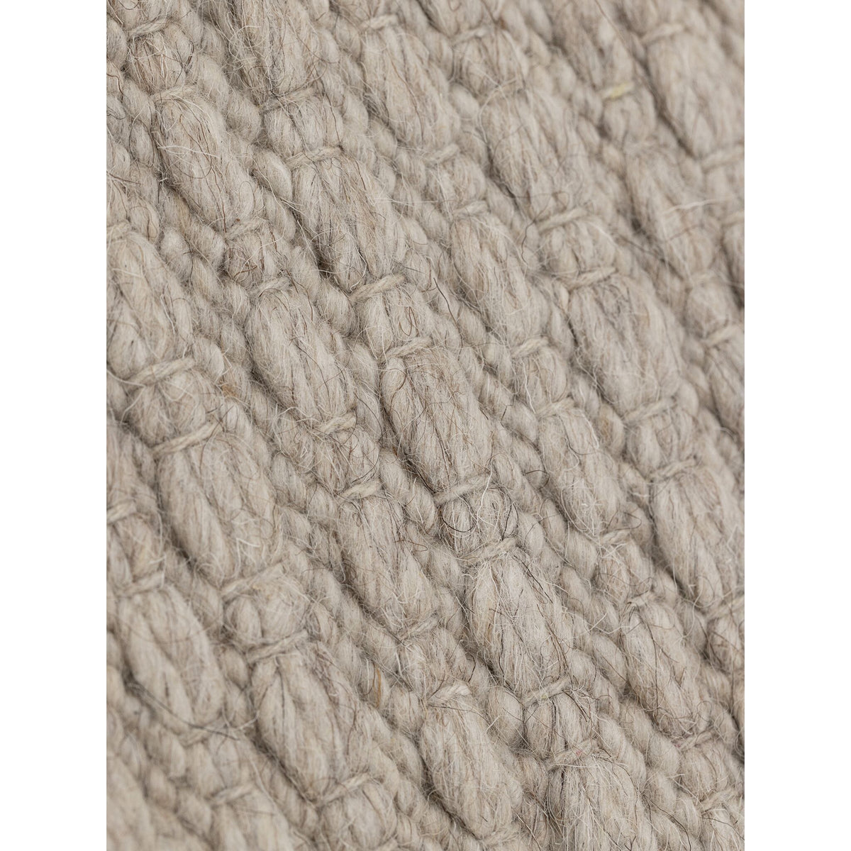 Nirvana vloerkleed van MUST Living in beige, detail van het gevlochten reliëfpatroon in de weving