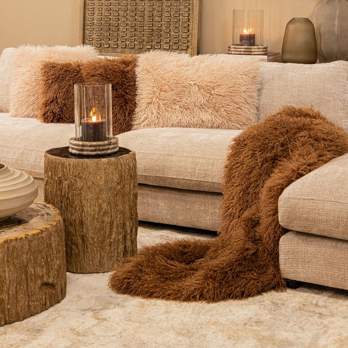 Rexx donkerbruine imitatiebont plaid S van PTMD, gestyled met kussens in een warme interieursetting