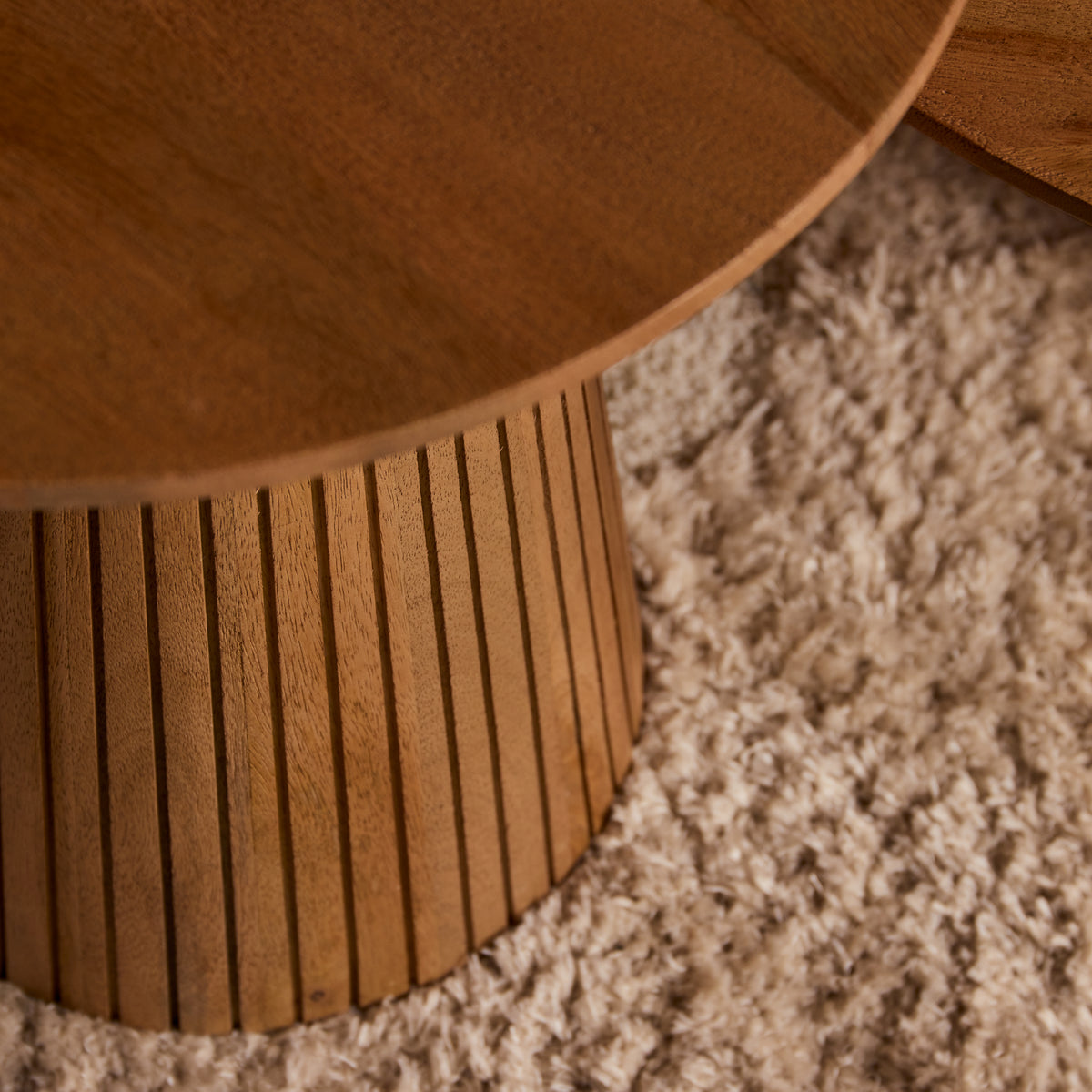 Kleine ronde Solana salontafel van mangohout in een warm ingerichte zithoek
