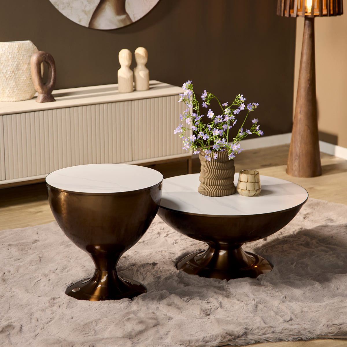 Salontafels Ava van marmer met goud in een woonkamer, naast een bank met een vloerkleed